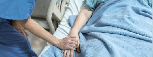 caregiver holding a patient's hand