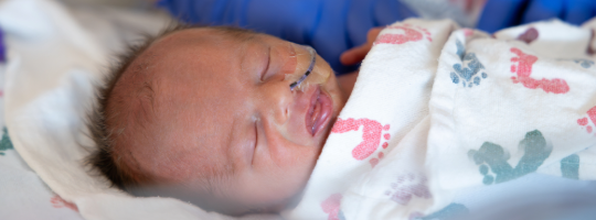 neonate baby under blanket
